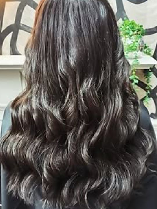 After: the same client with long, thick espresso-brown waves falling well past the shoulders.